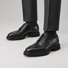 Black calfskin apron-toe Derby lug sole shoes — premium on-foot studio view