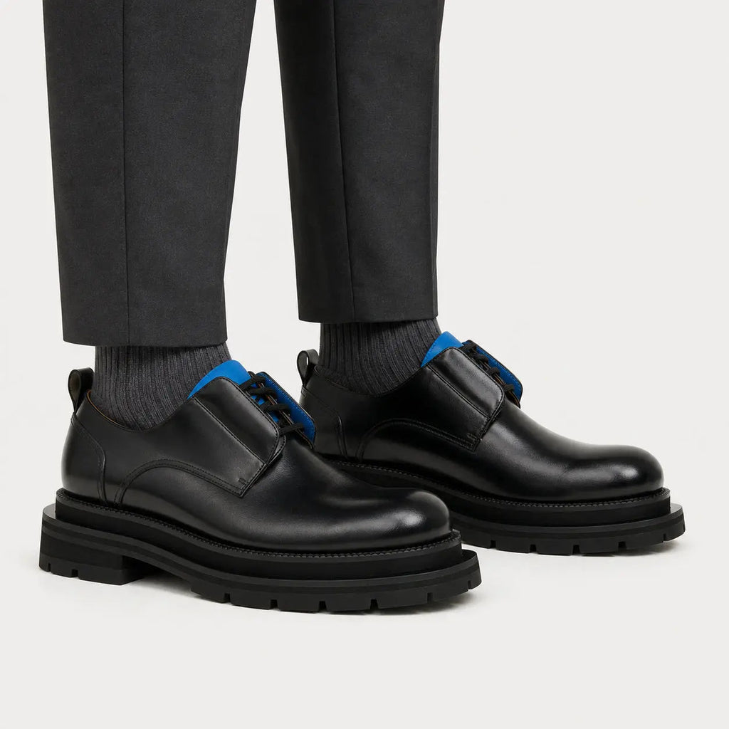 Black and blue lug sole Derby shoes on foot