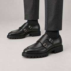 Black apron-toe double monk strap lug sole shoes — premium on-foot studio view