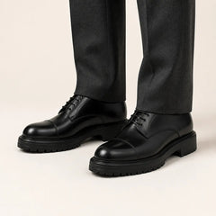 Black Lug Sole Derby on foot, warm off-white studio