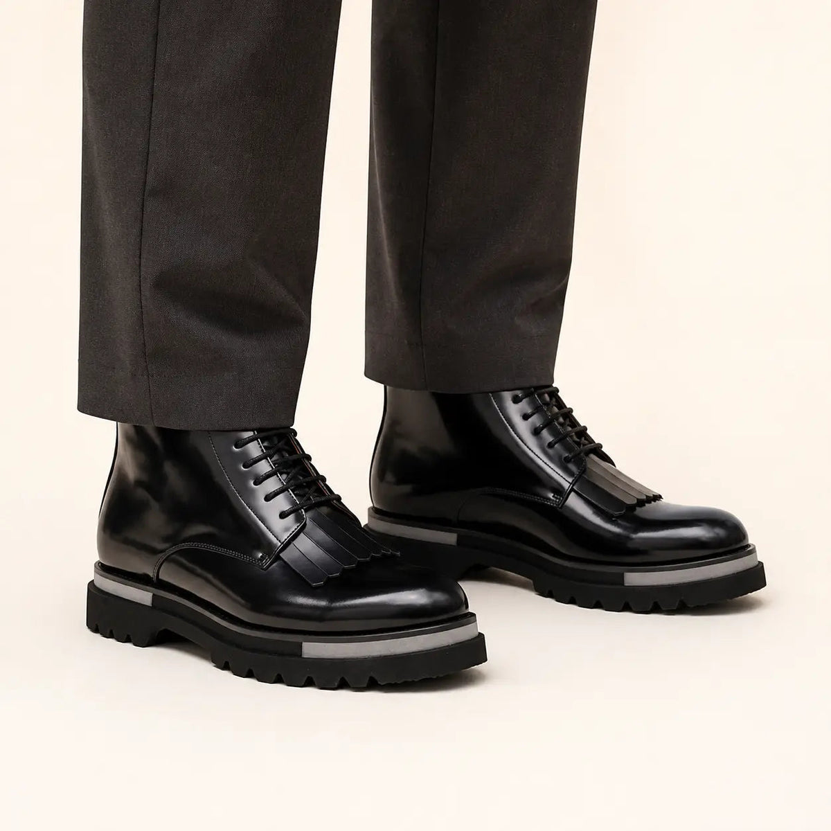 DIVINCH black patent kiltie lace up boots on foot in warm studio