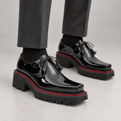 Black patent square-toe Derby shoes on foot