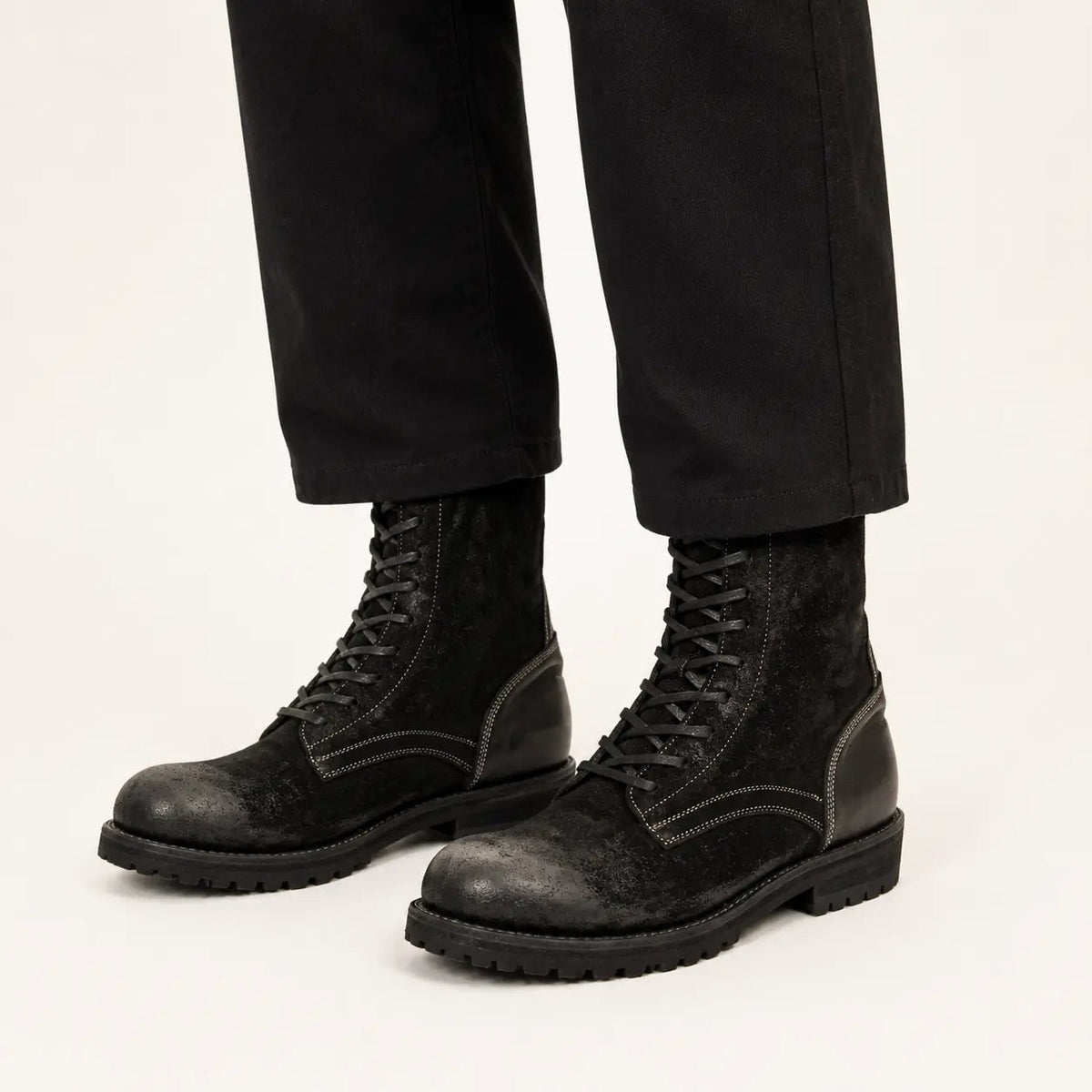 DIVINCH black suede lace-up combat boots on foot in warm studio