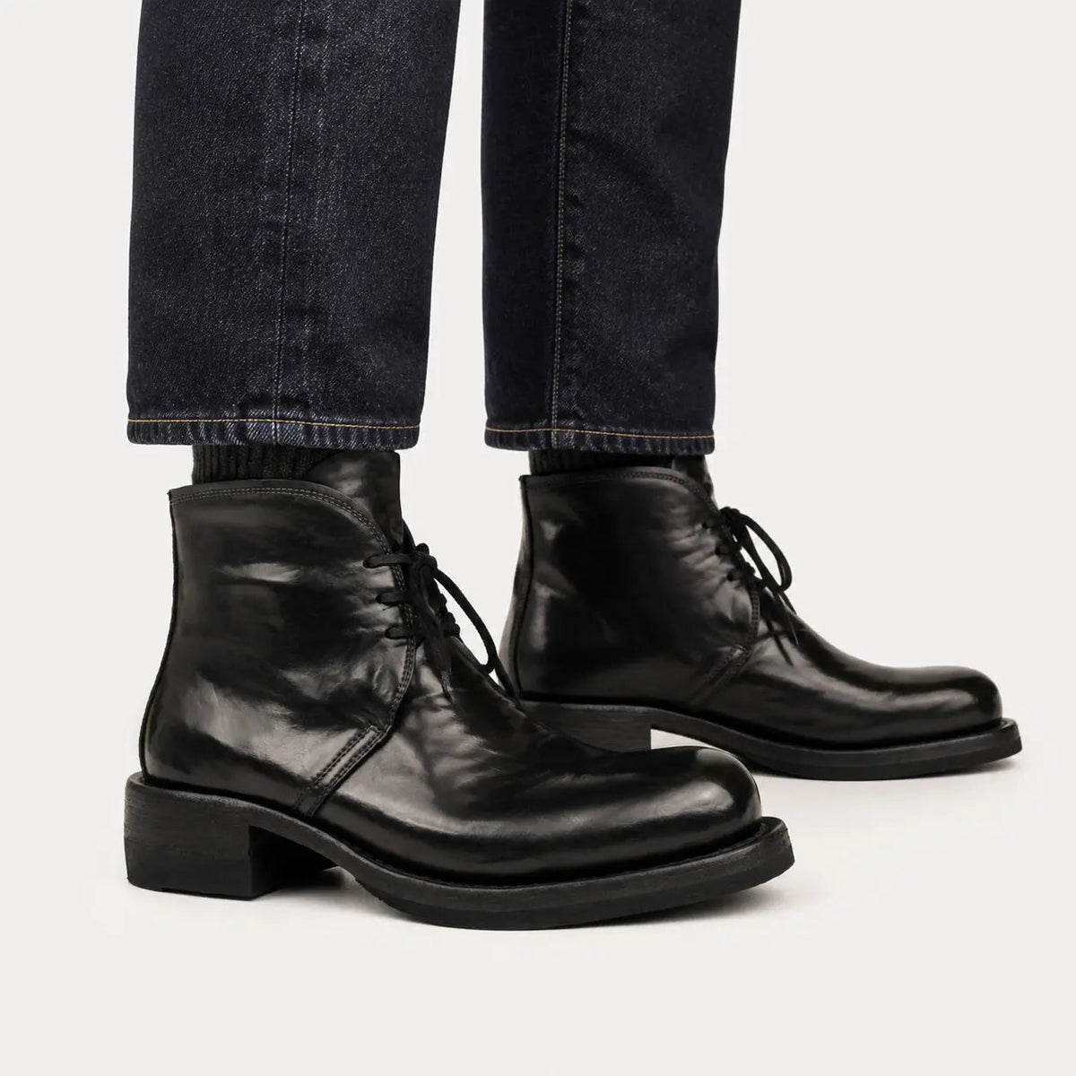 Black washed leather lace-up ankle boots worn with raw indigo denim