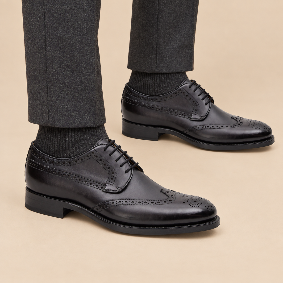 Black wingtip Derby shoes with polished finish on model