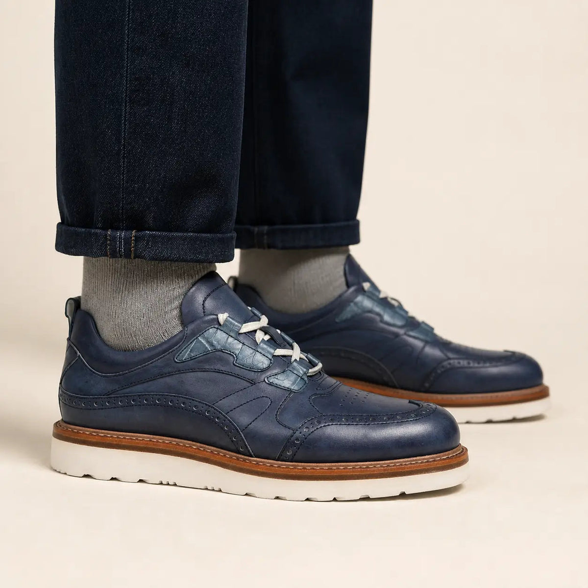 Blue brogue casual shoes with white sole on foot