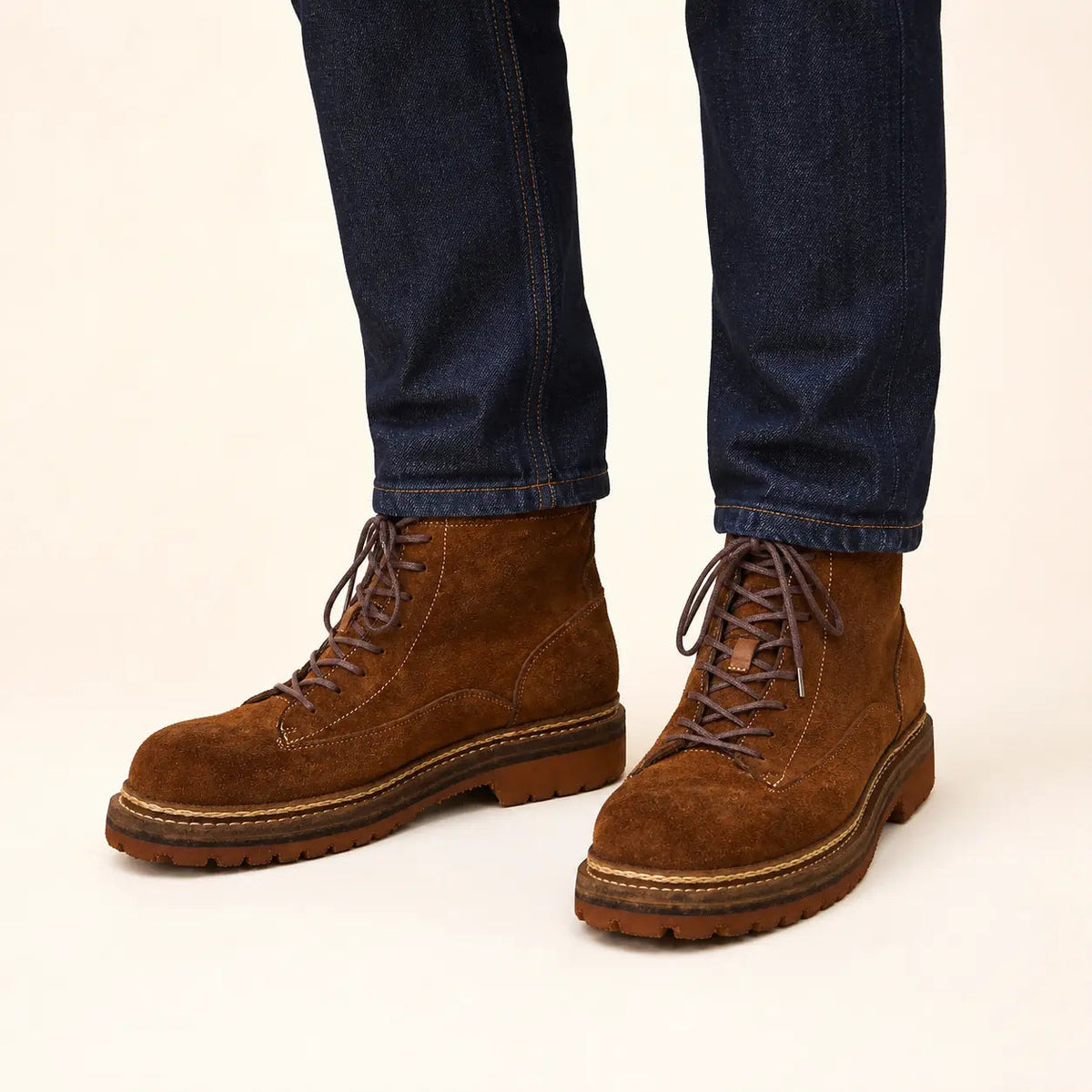 Brown suede combat boots with tan lug sole on-foot studio photo