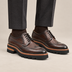 Brown wingtip Derby shoes with brown-band lug sole — premium on-foot studio view