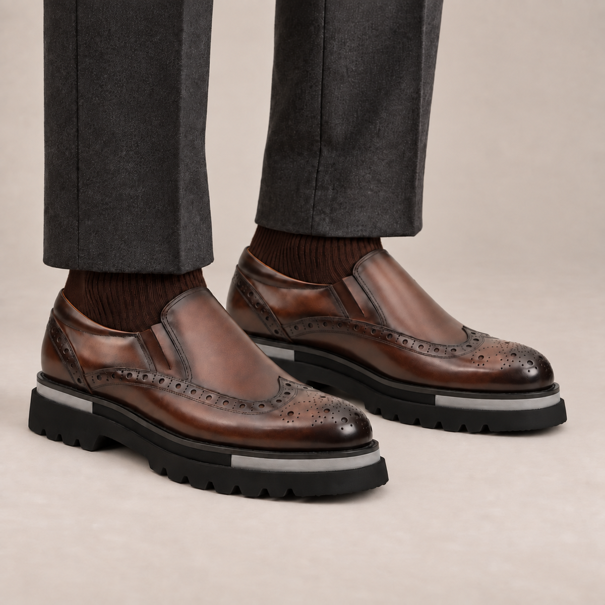 DIVINCH shaded brown glossy wingtip brogue lug-sole slip-on shoes worn with tailored charcoal trousers