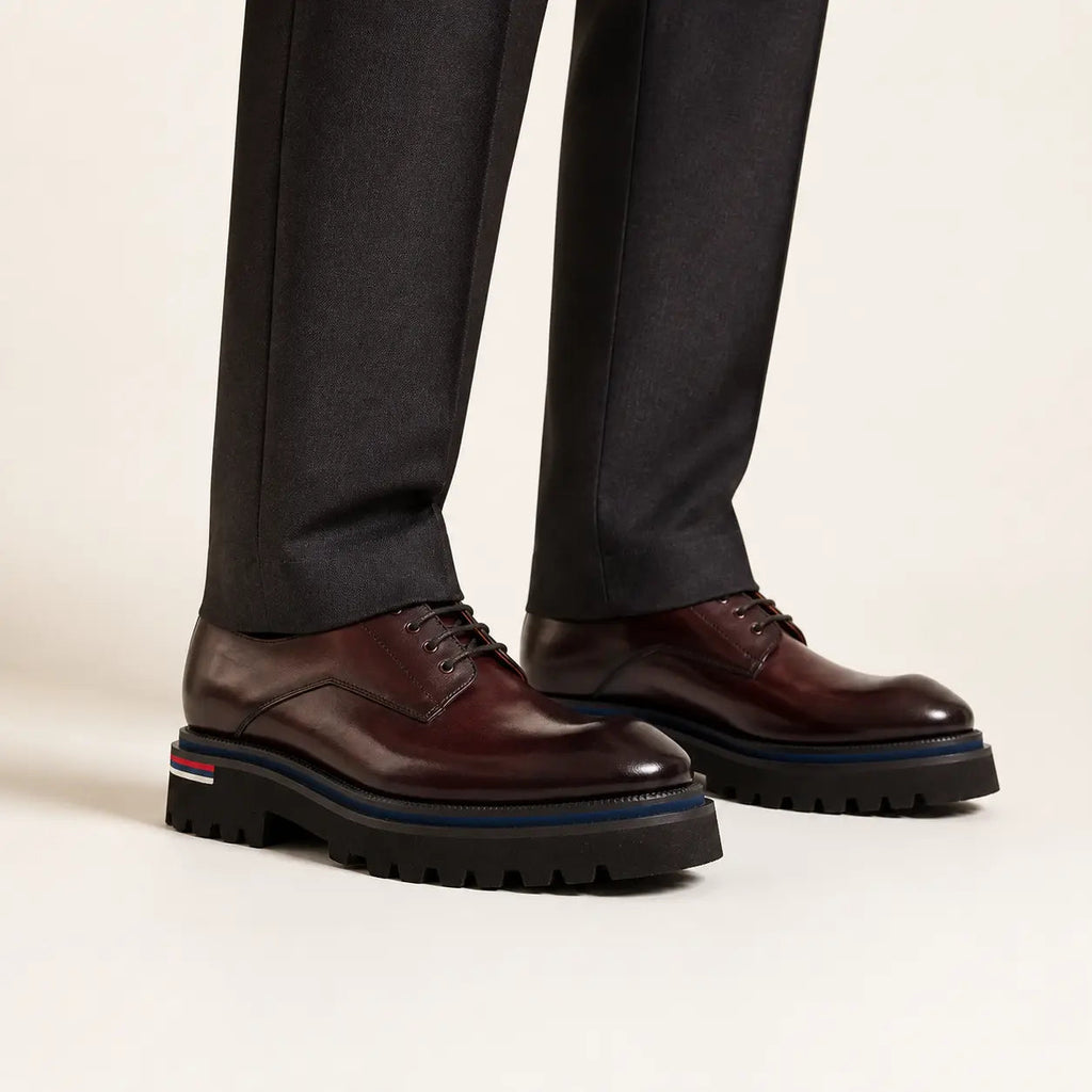 Burgundy Lug Sole Derby on foot, warm off-white studio