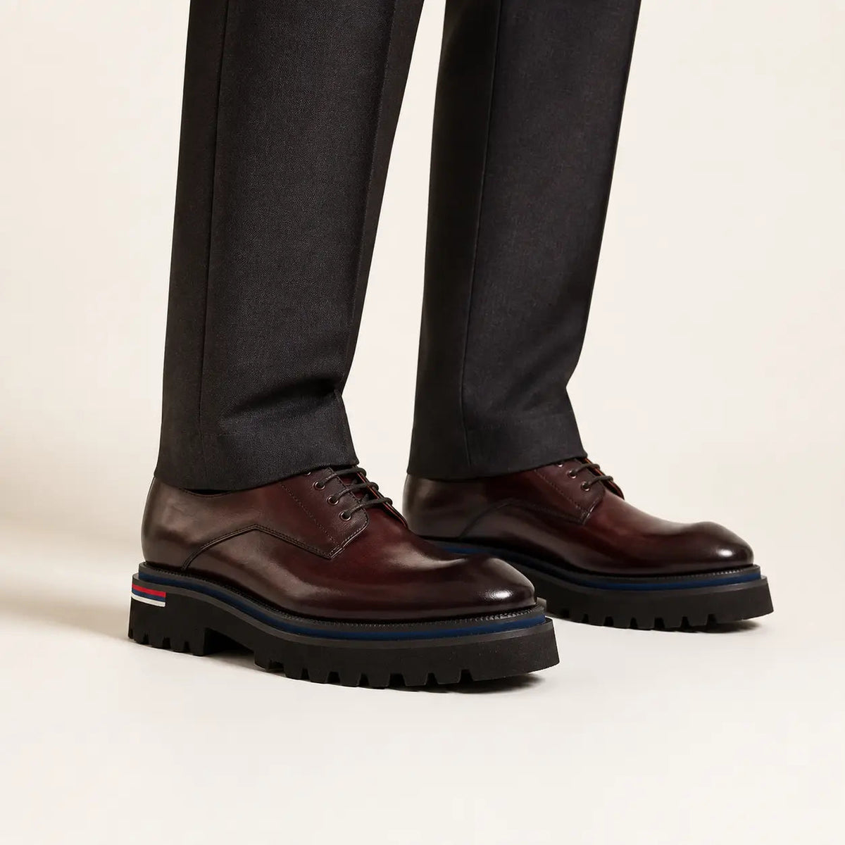 Burgundy Lug Sole Derby on foot, warm off-white studio