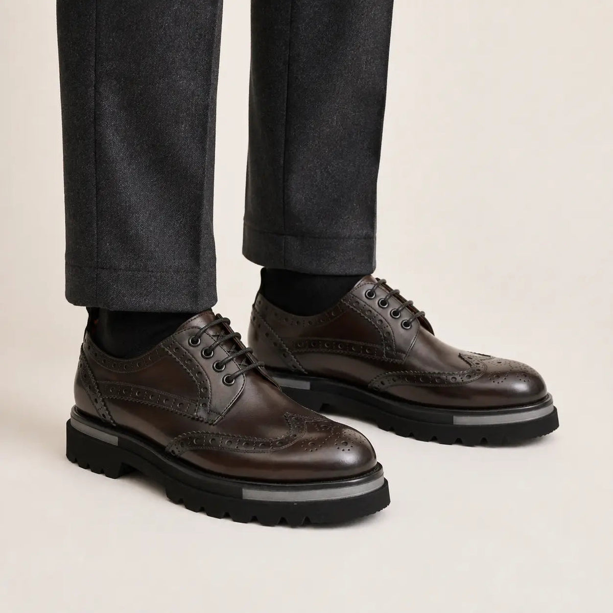 Burnished wingtip brogue lug-sole Derby shoes on foot