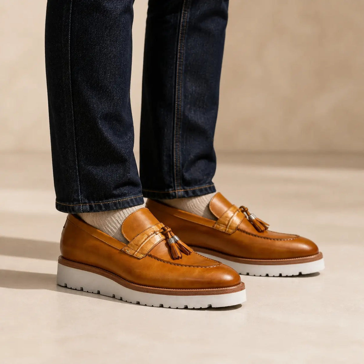 Cognac tassel loafer with white lug sole on foot
