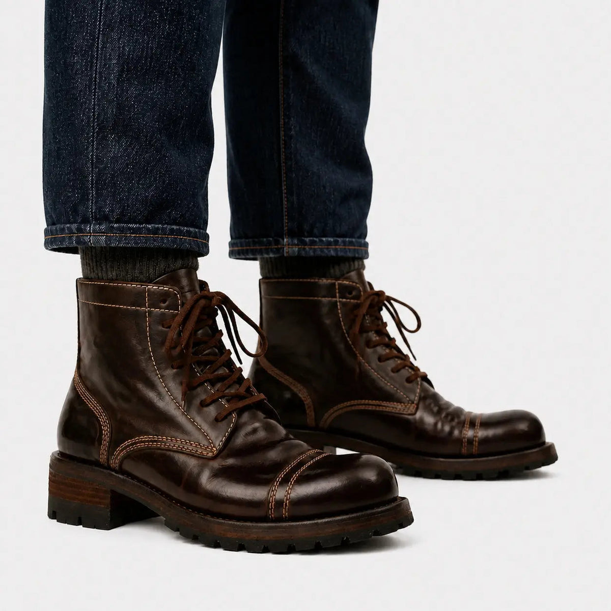 Dark brown washed horsehide combat boots worn with raw indigo denim