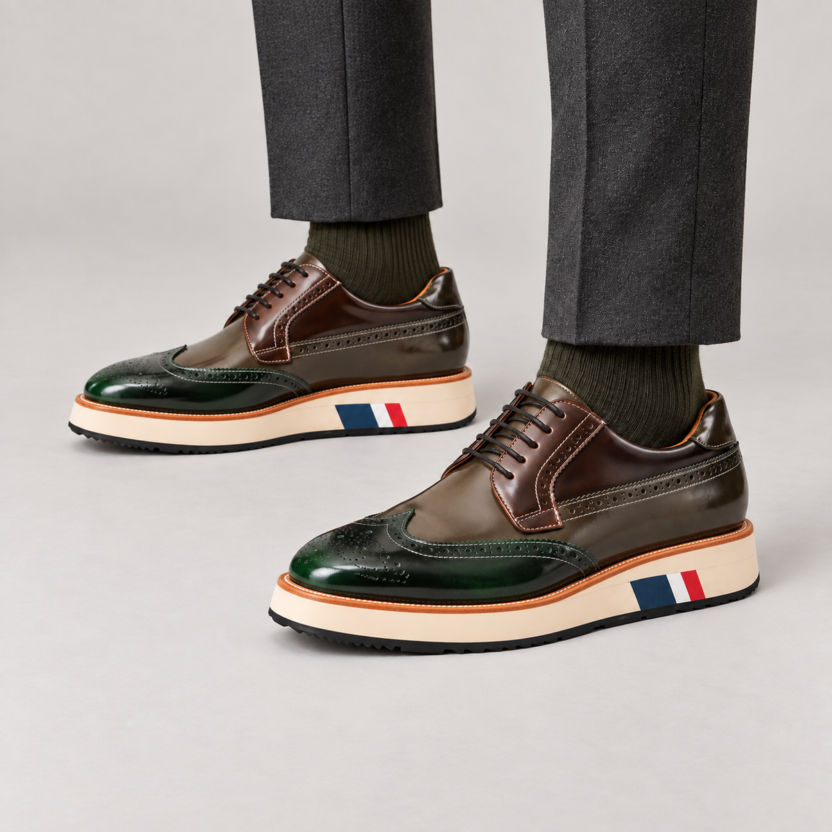 Green and brown glossy wingtip Derby shoes with contrast platform sole — premium on-foot studio view