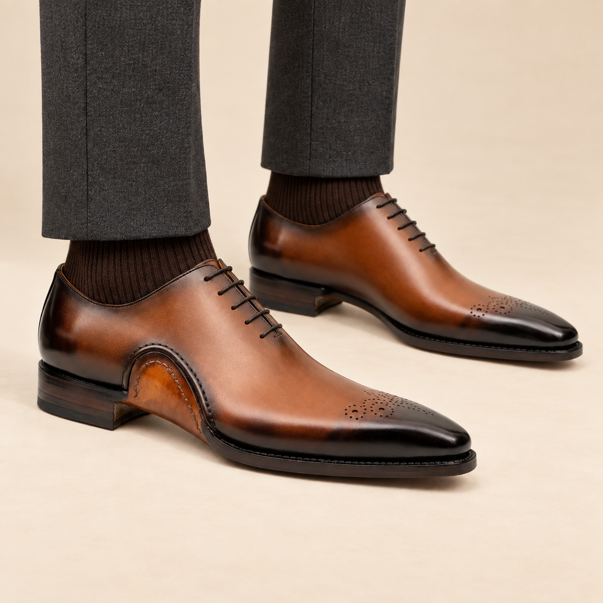 Tan-brown square-toe Oxford shoes on foot with correct outer-side detailing